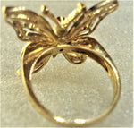 Butterfly with gemstones inserted into an 18-karat gold ring rear behind