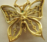 Butterfly with gemstones inserted into an 18-karat gold necklace rear behind